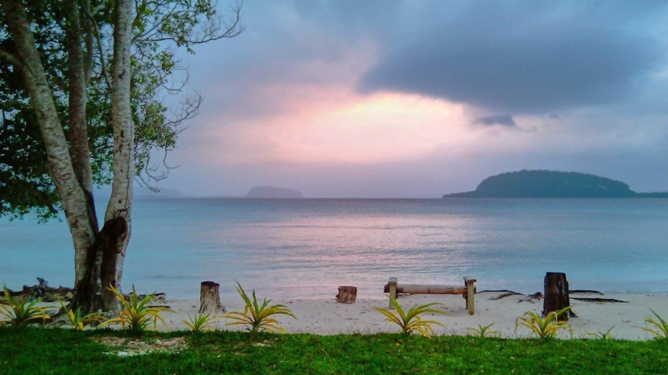 Pink sunset from beach over the sea and an island